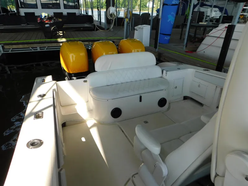 Slide: The Image of 2004 Fountain 38 Sportfish CC boat interior with seating and yellow engines at dock. - 10
