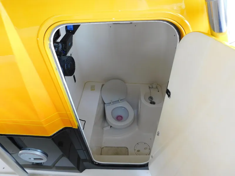 Slide: The Image of 2004 Fountain 38 Sportfish CC boat bathroom with yellow exterior and white interior. - 17