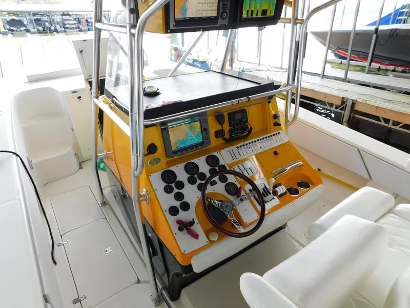 Slide: The Image of 2004 Fountain 38 Sportfish CC boat cockpit with yellow console and navigation equipment. - 33