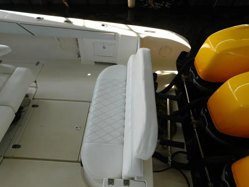 Slide: The Image of 2004 Fountain 38 Sportfish CC boat interior with white seating and yellow engines. - 35