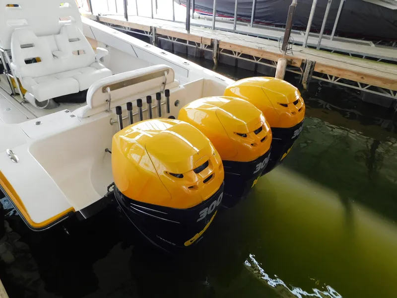 Slide: The Image of 2004 Fountain 38 Sportfish CC with triple yellow outboard engines docked in water. - 45