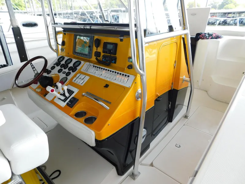 Slide: The Image of 2004 Fountain 38 Sportfish CC boat cockpit with yellow dashboard and navigation controls. - 9