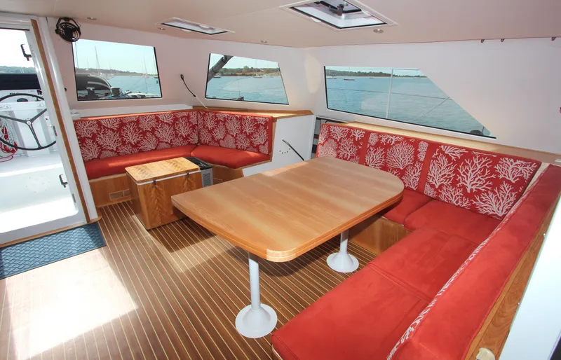 Slide: The Image of Luxurious interior of 2018 Chris White Atlantic 70 "SAPHIRA" with red seating and wooden table. - 12