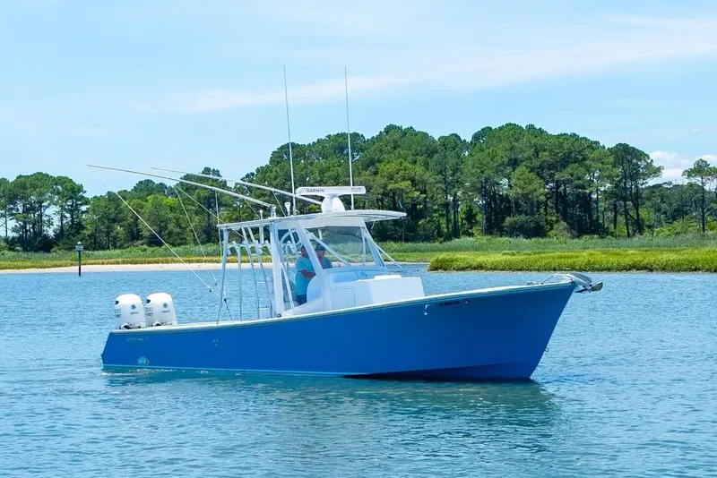 Slide: The Image of Blue Custom 31 boat (2020) cruising on a calm lake with forested shoreline. - 10