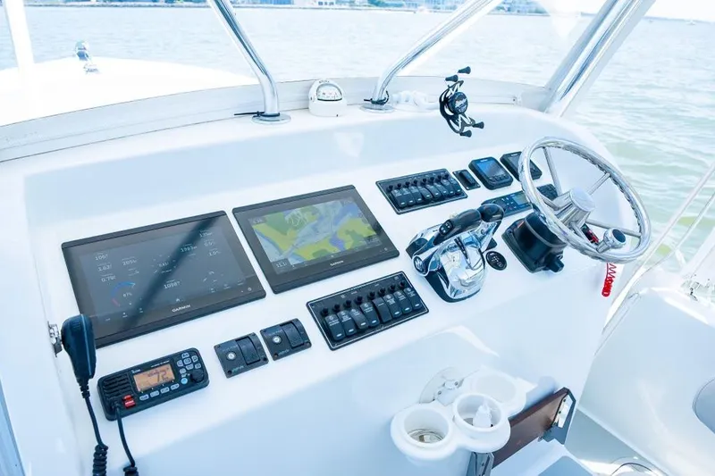 Slide: The Image of Custom 31 boat dashboard with navigation screens, steering wheel, and control panels, 2020 model. - 21