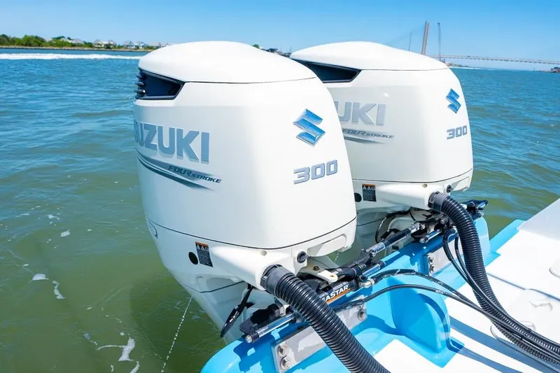 Slide: The Image of Twin Suzuki 300 outboard motors on a Custom 31 boat, 2020 model, in open water. - 24