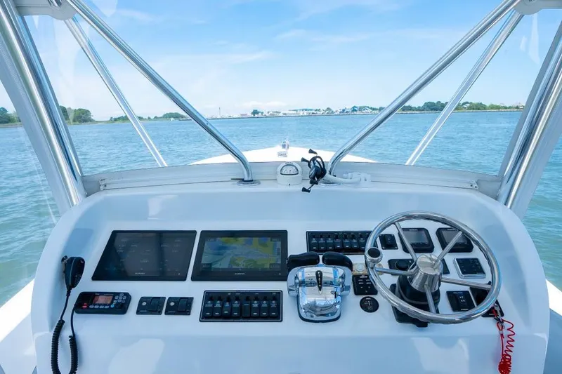 Slide: The Image of Custom 31 boat dashboard with navigation screens and steering wheel, 2020 model on water. - 33