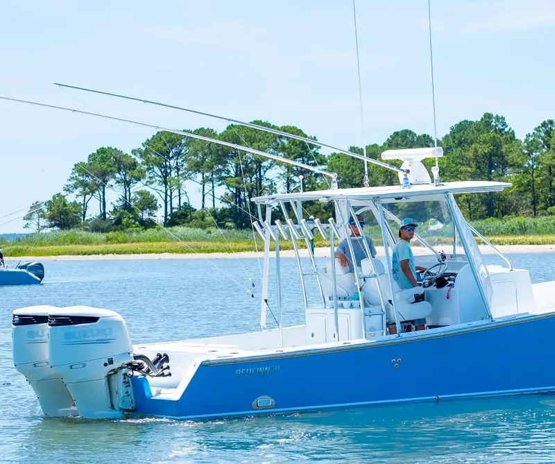 Slide: The Image of Custom 31 boat, 2020 model, cruising on a lake with trees in the background. - 8