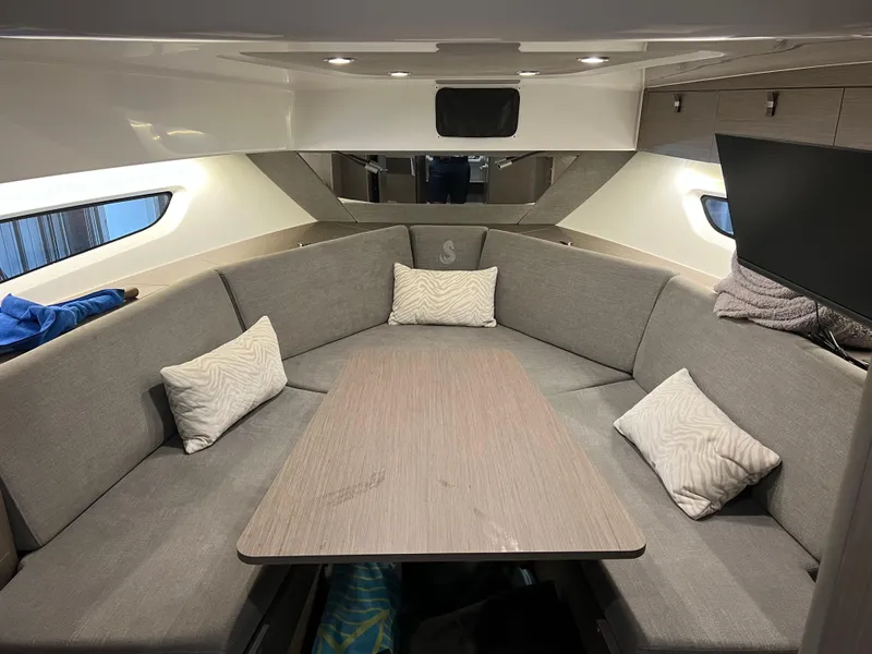 Slide: The Image of Interior of 2023 Beneteau Gran Turismo 32 with grey seating and wooden table. - 12