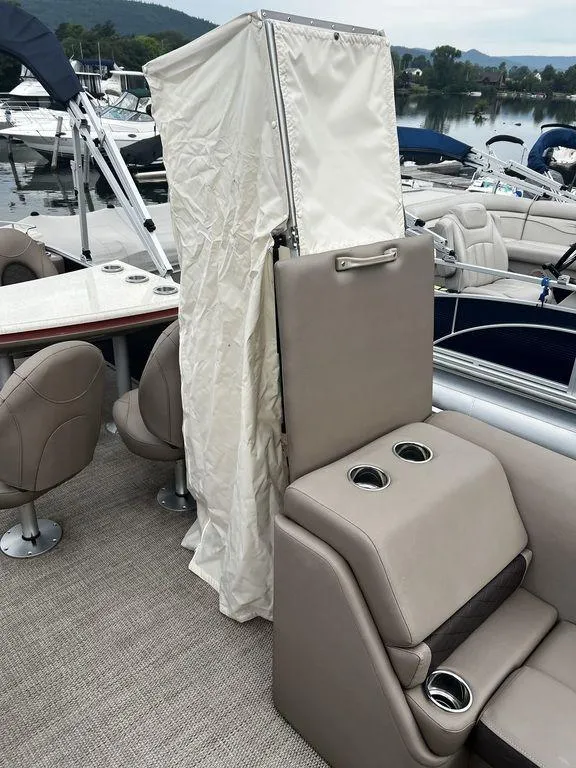 Slide: The Image of 2019 Bennington 25 SPDXP boat interior with beige seating and cup holders. - 10
