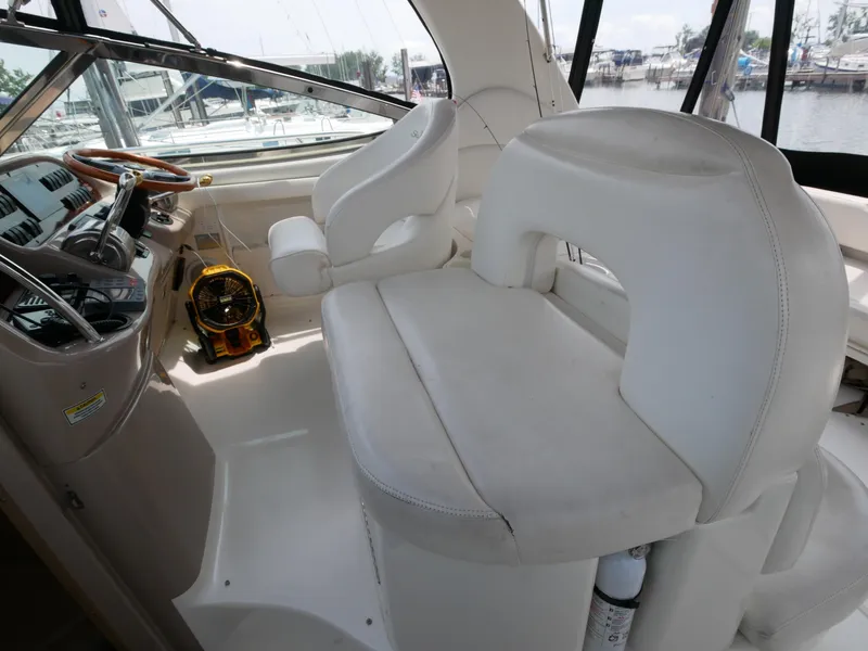 Slide: The Image of 2002 Sea Ray 360 Sundancer helm with white leather seating and steering wheel. - 12