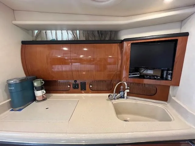 Slide: The Image of 2002 Sea Ray 360 Sundancer yacht kitchen with sink, coffee maker, and TV. - 28