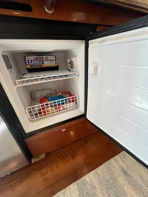 Slide: The Image of Open freezer inside a 2002 Sea Ray 360 Sundancer boat, showing food items. - 33