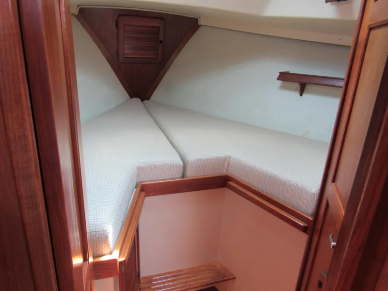 Slide: The Image of 1987 Island Packet 31 sailboat cabin with cozy V-berth and wooden interior. - 10