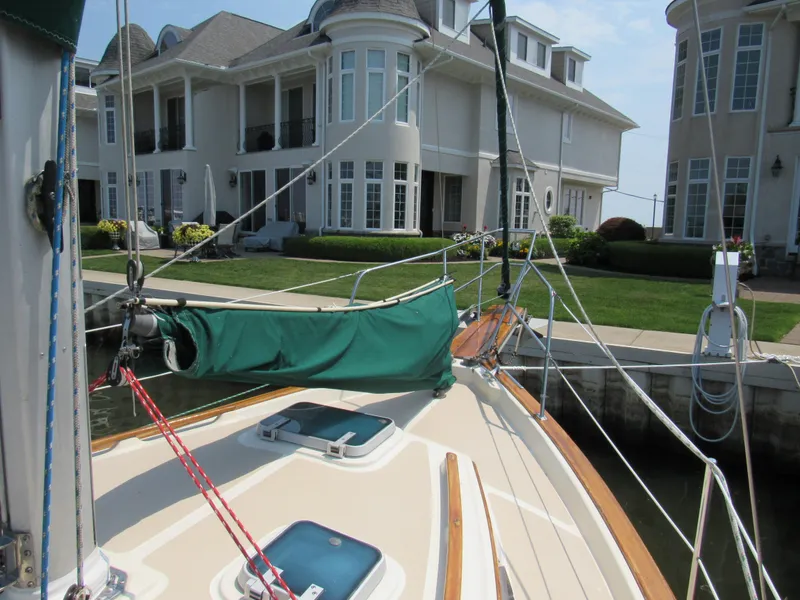 Slide: The Image of 1987 Island Packet 31 sailboat docked near elegant waterfront homes. - 12