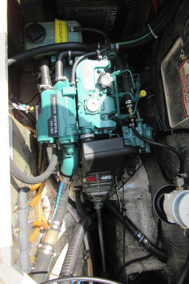 Slide: The Image of Engine compartment of a 1987 Island Packet 31 sailboat, showcasing mechanical components and wiring. - 18