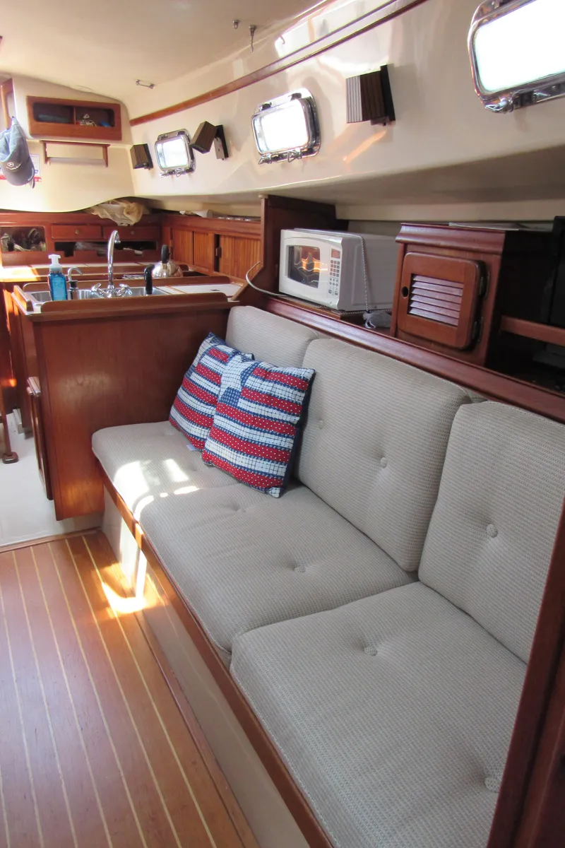 Slide: The Image of Interior of 1987 Island Packet 31 sailboat with cozy seating and kitchen area. - 4