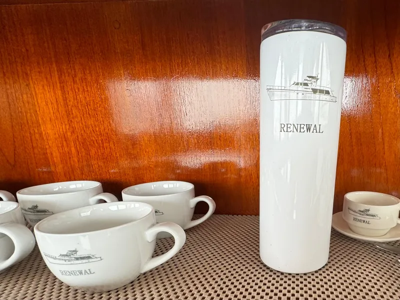 Slide: The Image of White mugs and tumbler with "Renewal" logo on wooden shelf, Nordlund 60 Motoryacht 1976. - 10