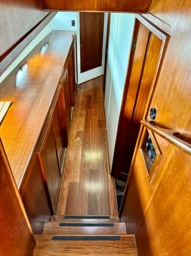 Slide: The Image of Interior hallway of a 1976 Nordlund 60 Motoryacht with wooden flooring and cabinetry. - 11