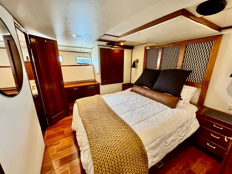 Slide: The Image of Luxurious 1976 Nordlund 60 Motoryacht bedroom with elegant wood finishes and cozy bedding. - 12