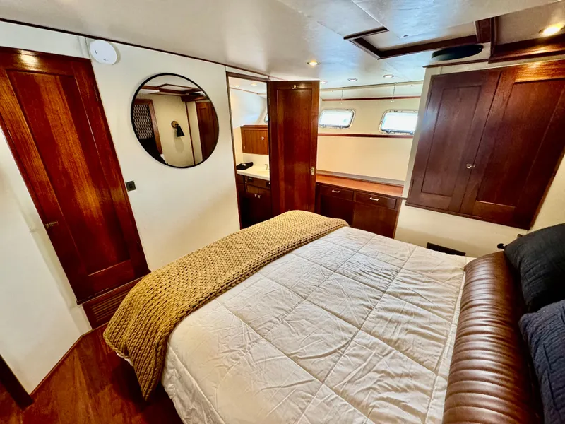 Slide: The Image of Luxurious cabin interior of a 1976 Nordlund 60 Motoryacht with wood accents and cozy bedding. - 13