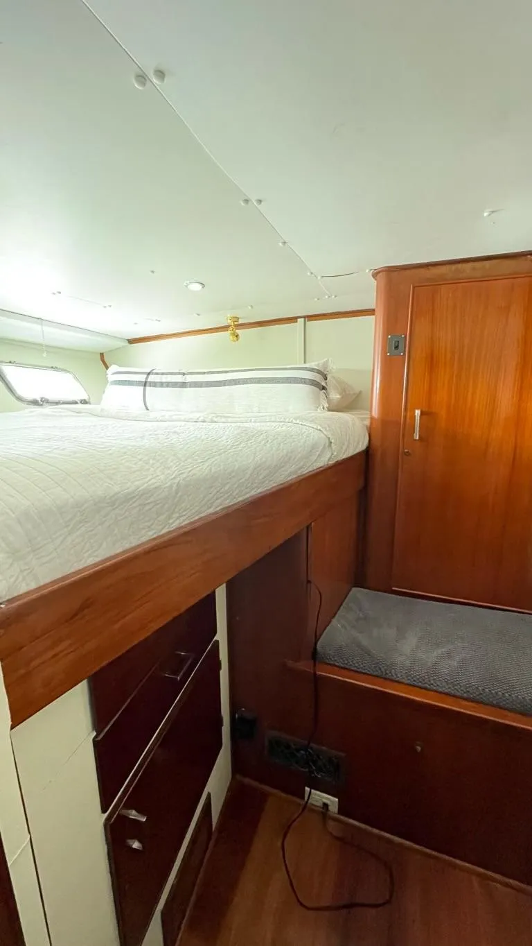 Slide: The Image of Interior of a 1976 Nordlund 60 Motoryacht with a cozy bed and wooden cabinetry. - 21