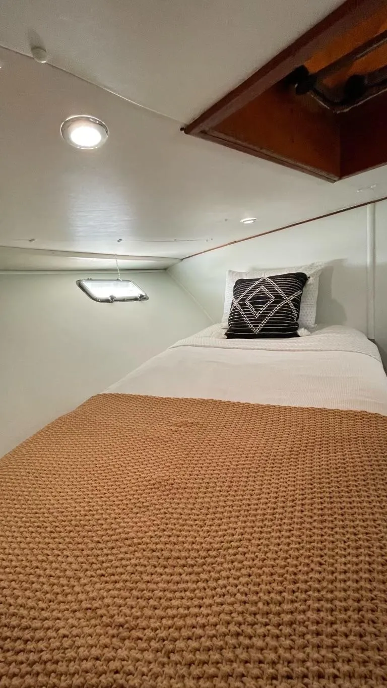 Slide: The Image of Cozy cabin interior of 1976 Nordlund 60 Motoryacht with single bed and decorative pillow. - 24