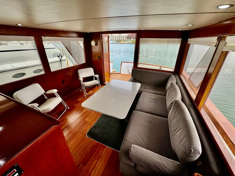 Slide: The Image of Interior of 1976 Nordlund 60 Motoryacht with seating and table, overlooking water. - 3