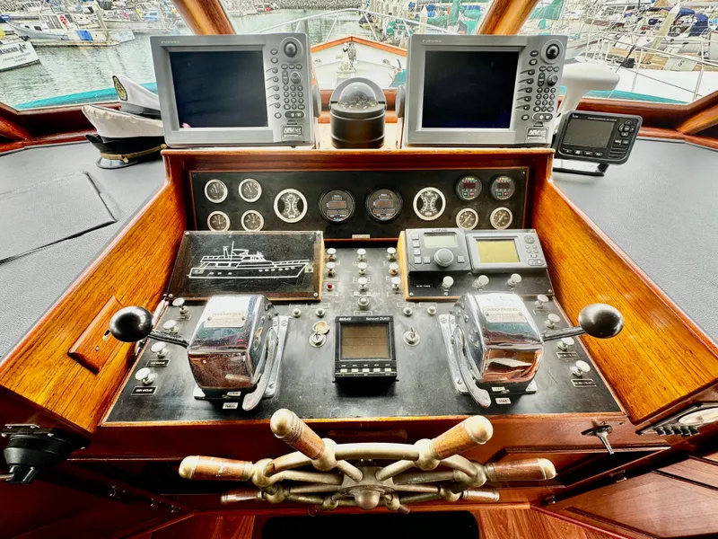Slide: The Image of 1976 Nordlund 60 Motoryacht helm with navigation instruments and wooden steering wheel. - 31