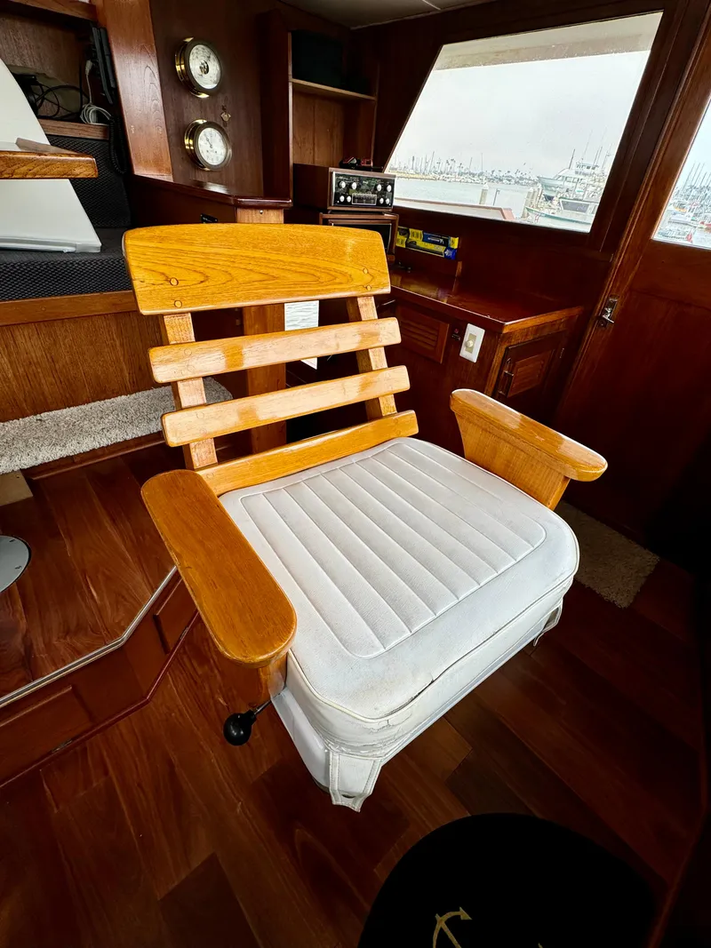 Slide: The Image of Wooden chair with white cushion in a 1976 Nordlund 60 Motoryacht interior. - 32