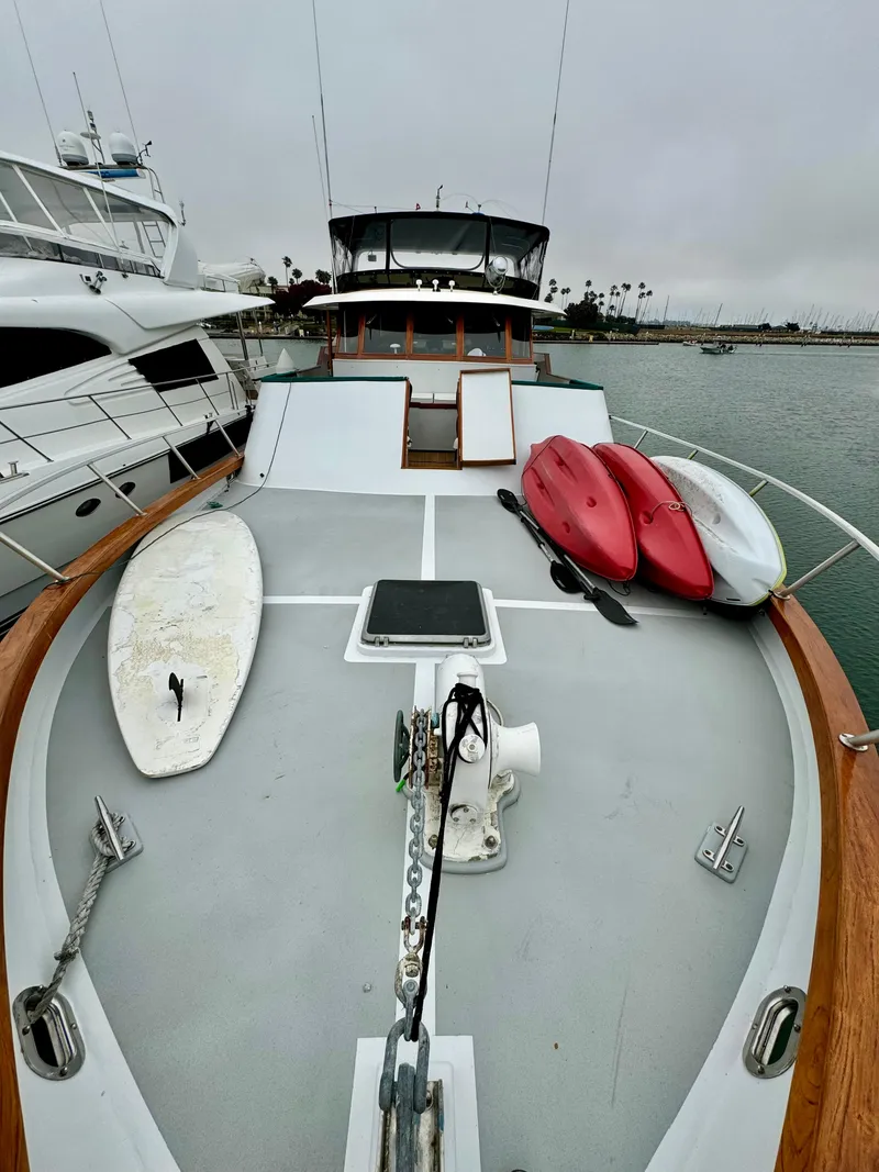 Slide: The Image of 1976 Nordlund 60 Motoryacht with kayaks and surfboard on deck, docked in a marina. - 43