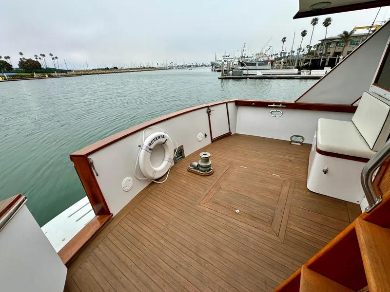 Slide: The Image of 1976 Nordlund 60 Motoryacht deck with wooden flooring and waterfront view. - 49
