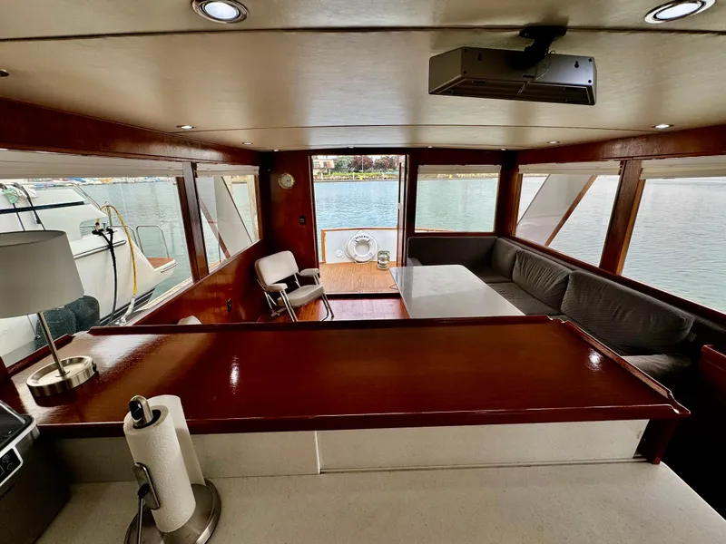 Slide: The Image of Interior of 1976 Nordlund 60 Motoryacht with wood accents and waterfront view. - 8