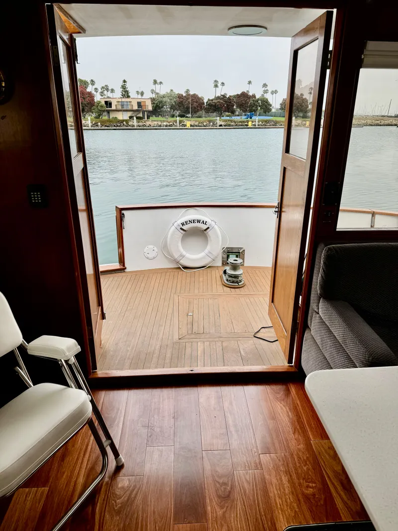 Slide: The Image of 1976 Nordlund 60 Motoryacht interior with open door to deck, overlooking calm waters. - 9