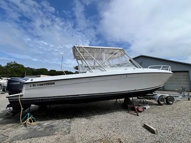 The Image of 2005 Contender 35 Side Console boat on trailer, parked outdoors under cloudy sky. - 0