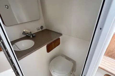 Slide: The Image of 2005 Contender 35 Side Console boat bathroom with sink and toilet. - 15