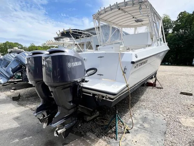 Slide: The Image of 2005 Contender 35 Side Console boat with twin Yamaha outboard engines, parked on gravel. - 2