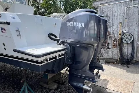 Slide: The Image of 2005 Contender 35 Side Console with Yamaha outboard motor, docked near a wooden shed. - 5