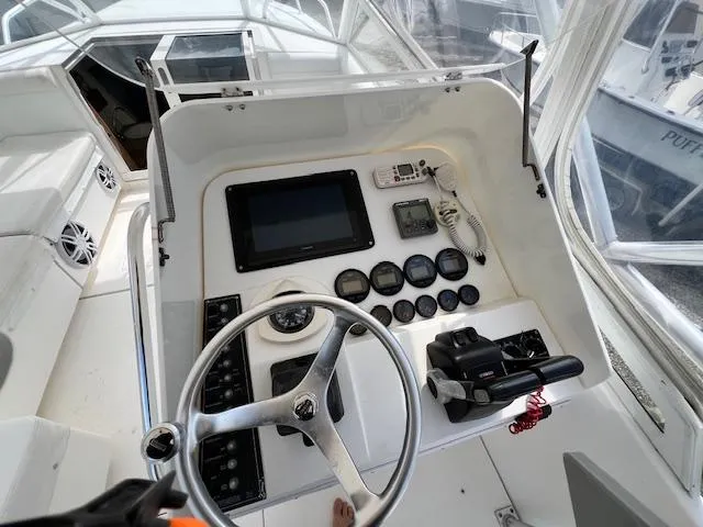 Slide: The Image of 2005 Contender 35 Side Console boat dashboard with steering wheel and navigation controls. - 7