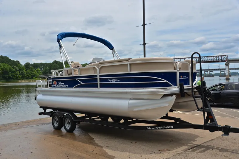 Slide: The Image of 2018 Sun Tracker Party Barge 20 DLX pontoon boat on trailer by the water. - 16