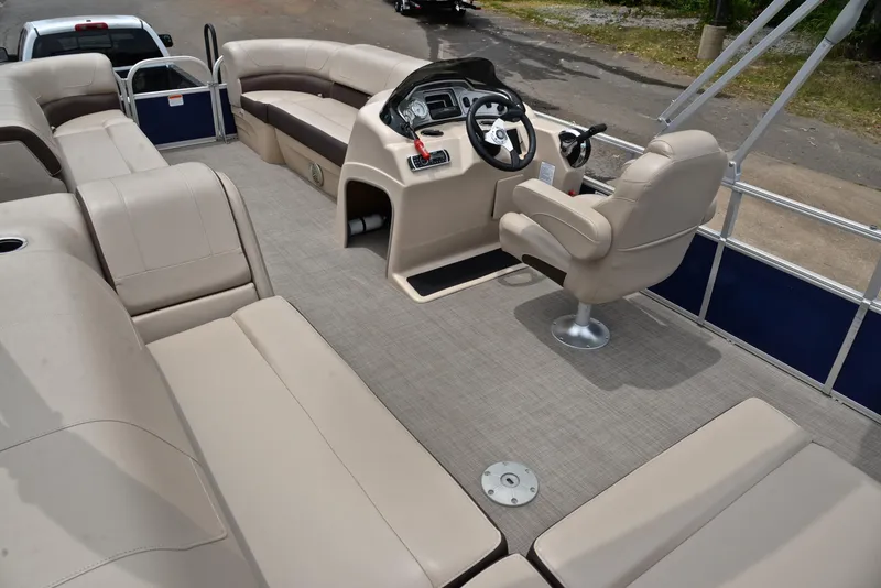 Slide: The Image of 2018 Sun Tracker Party Barge 20 DLX interior with beige seating and captain's chair. - 23