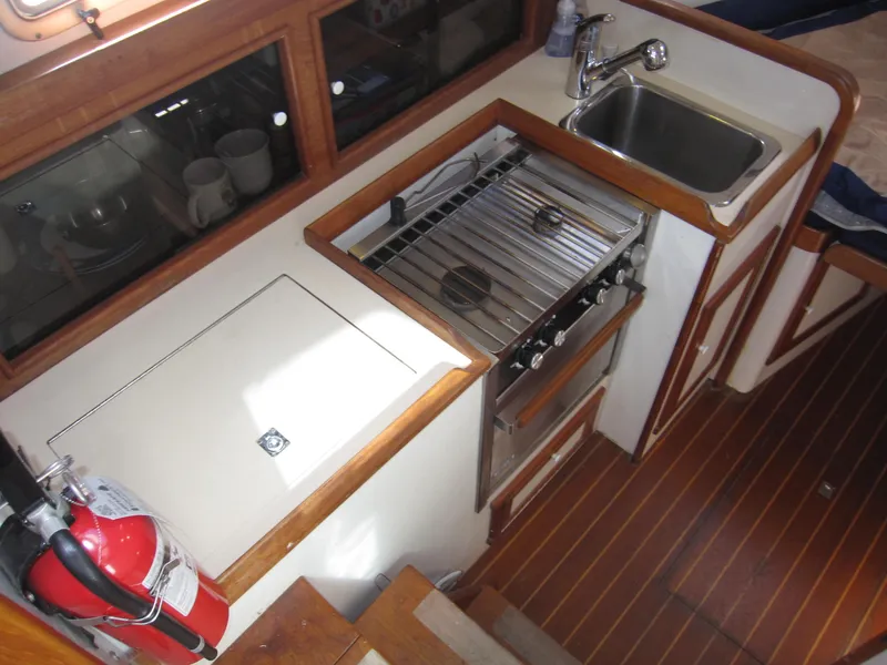 Slide: The Image of 1990 Blue Seas 31 Hardtop Cruiser galley with stove, sink, and fire extinguisher. - 10