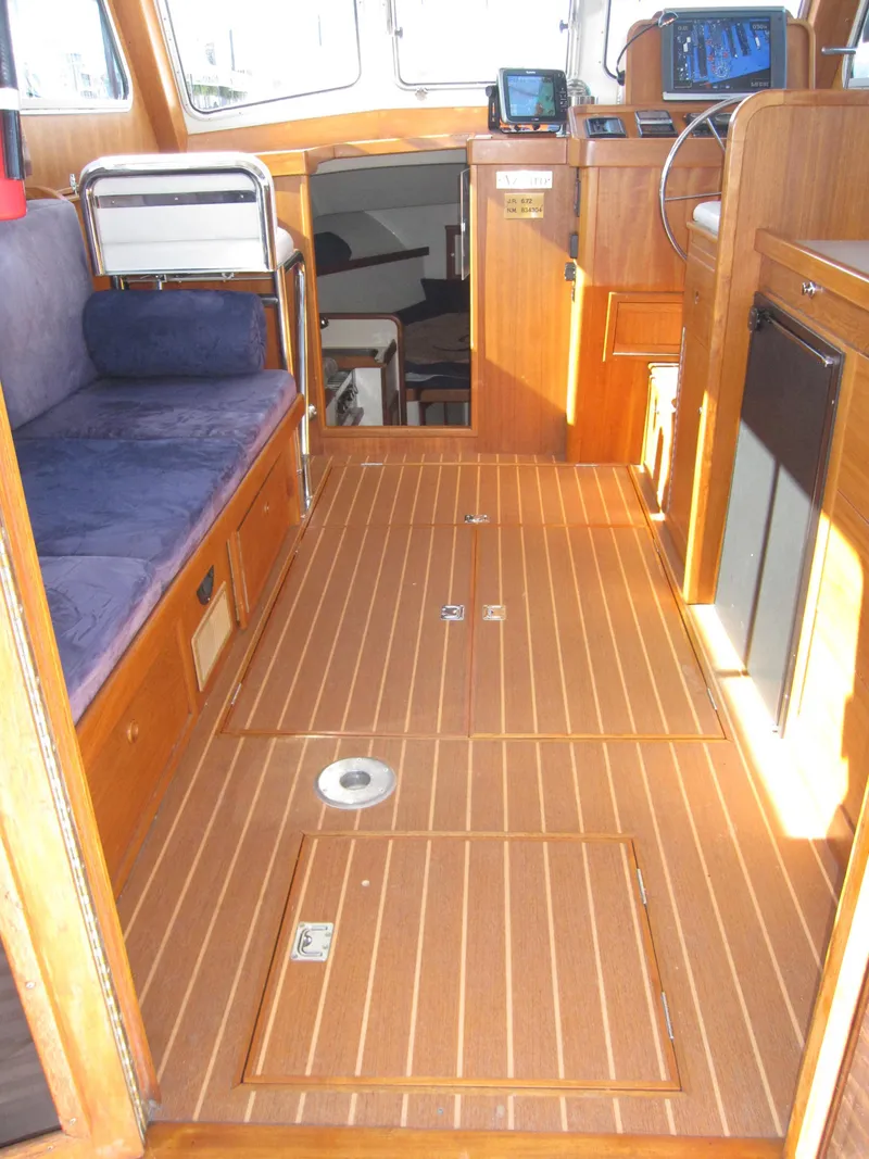Slide: The Image of Interior of a 1990 Blue Seas 31 Hardtop Cruiser with wooden flooring and seating. - 24