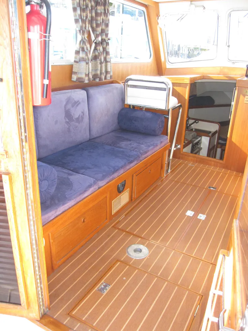 Slide: The Image of 1990 Blue Seas 31 Hardtop Cruiser interior with wooden flooring and blue seating. - 26
