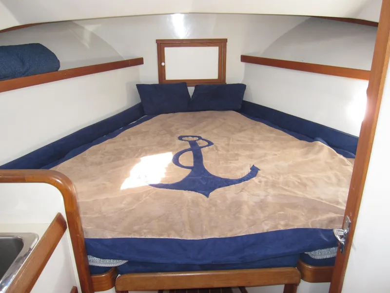 Slide: The Image of 1990 Blue Seas 31 Hardtop Cruiser cabin with anchor-themed bedding. - 3
