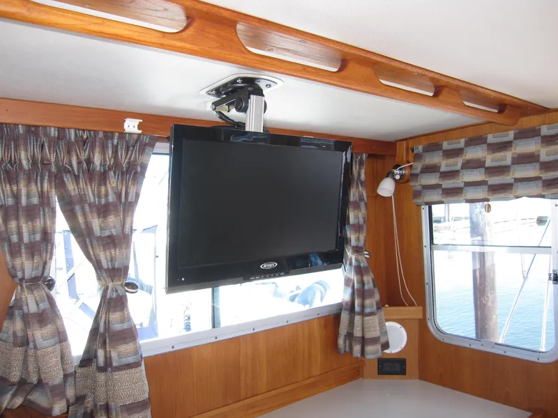 Slide: The Image of Interior of 1990 Blue Seas 31 Hardtop Cruiser with mounted TV and window curtains. - 33
