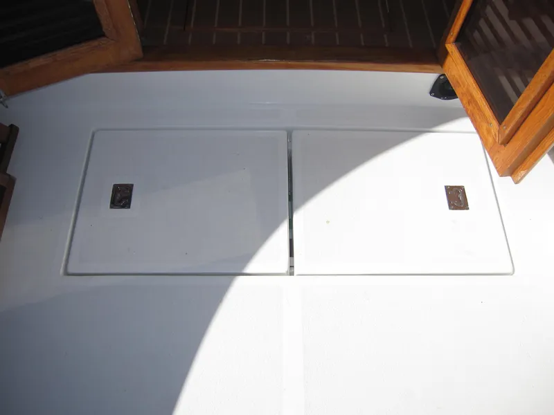 Slide: The Image of 1990 Blue Seas 31 Hardtop Cruiser deck with storage compartments and wooden trim. - 45