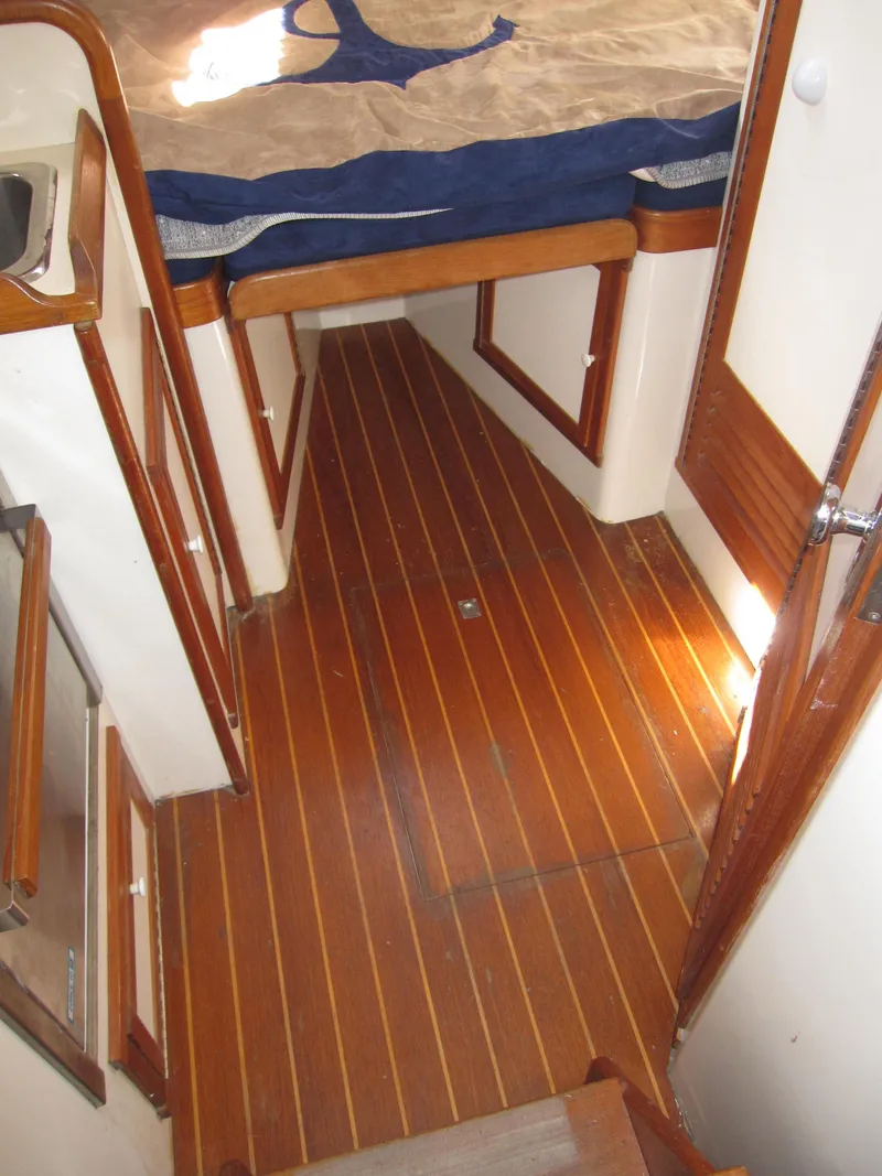 Slide: The Image of 1990 Blue Seas 31 Hardtop Cruiser interior with wooden flooring and cozy cabin. - 6
