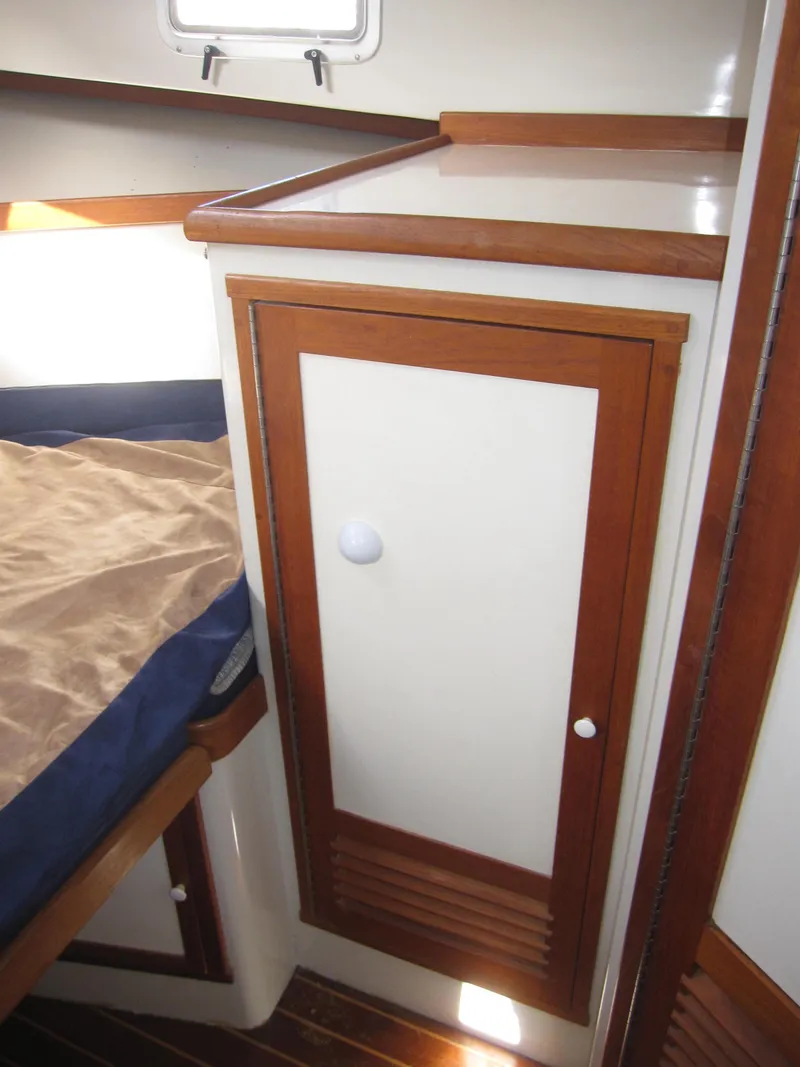 Slide: The Image of 1990 Blue Seas 31 Hardtop Cruiser cabin interior with wooden cabinetry and bed. - 7