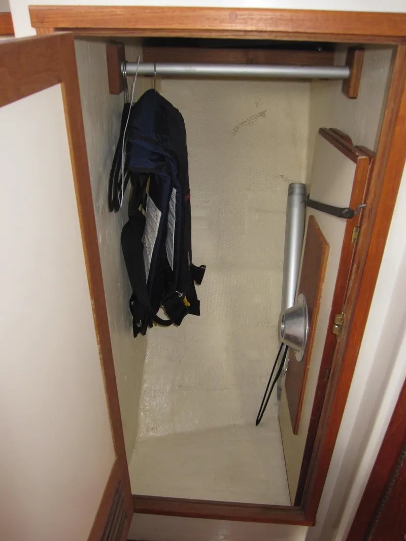Slide: The Image of Small closet in a 1990 Blue Seas 31 Hardtop Cruiser with hanging clothes. - 8
